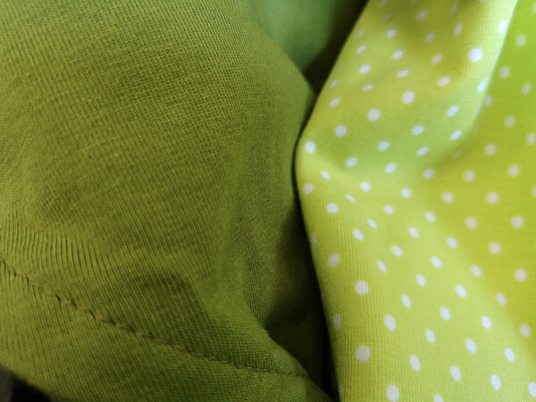 Einschlagdecke-Sommer-Trico-kaki-Punkte-grün-mit-Puppe-in-Babyschale-Shop